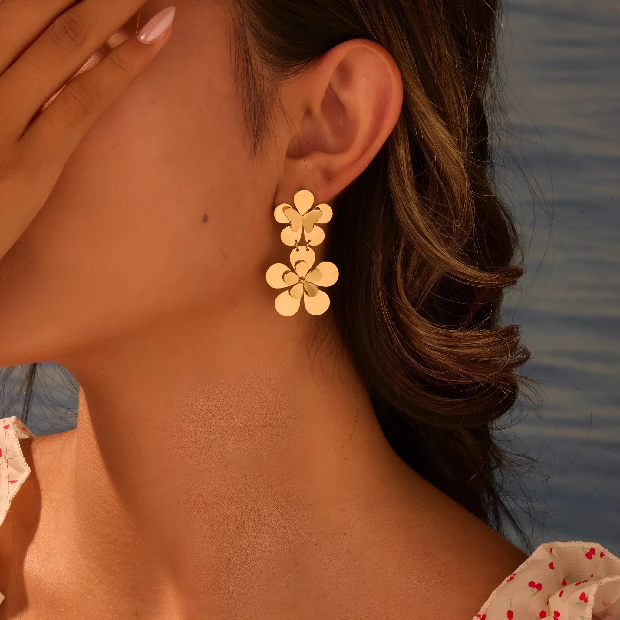 Gold-coloured flower butterfly earrings with geometric design elements on stainless steel