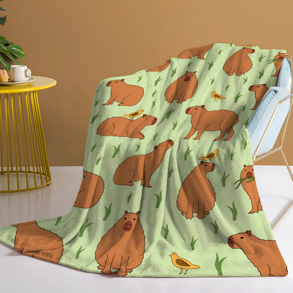 Multicolored flannel blanket with bird and capybara combined pattern on a sofa