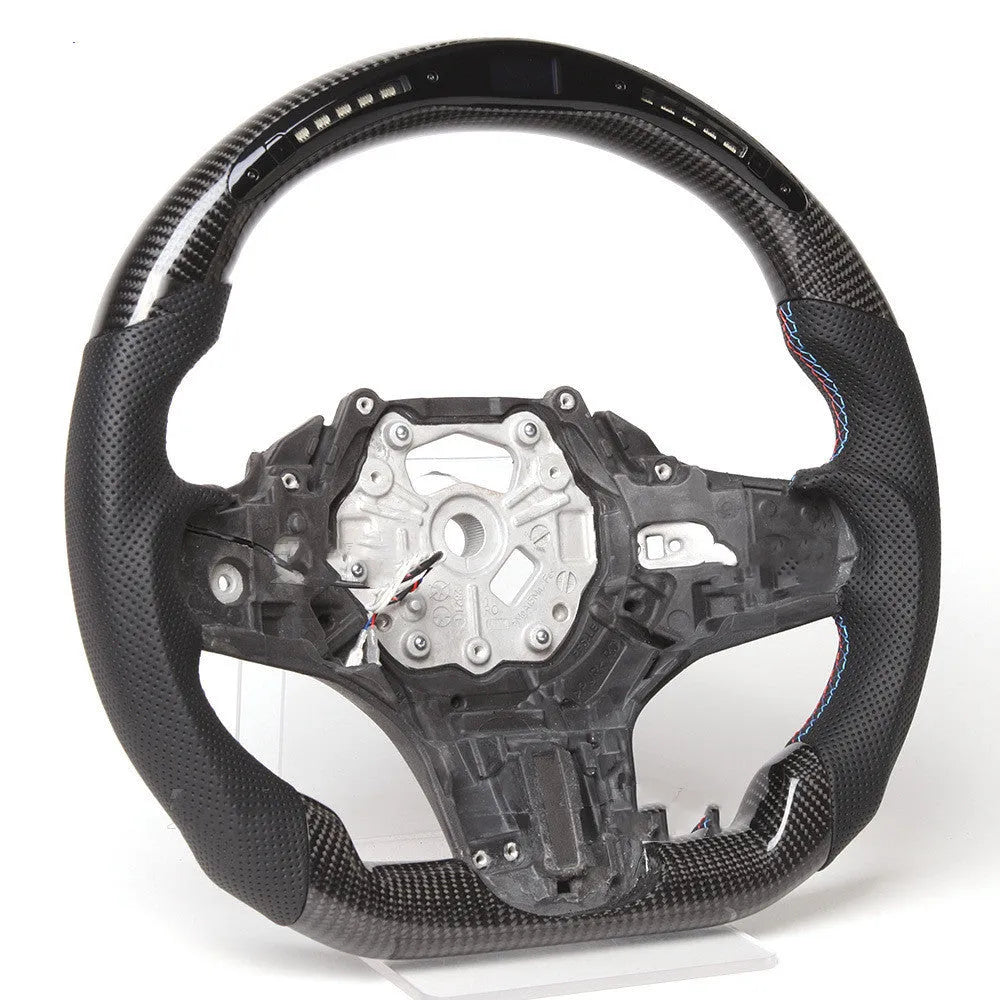 Black carbon fibre BMW sports steering wheel with LED display and multifunctional buttons.