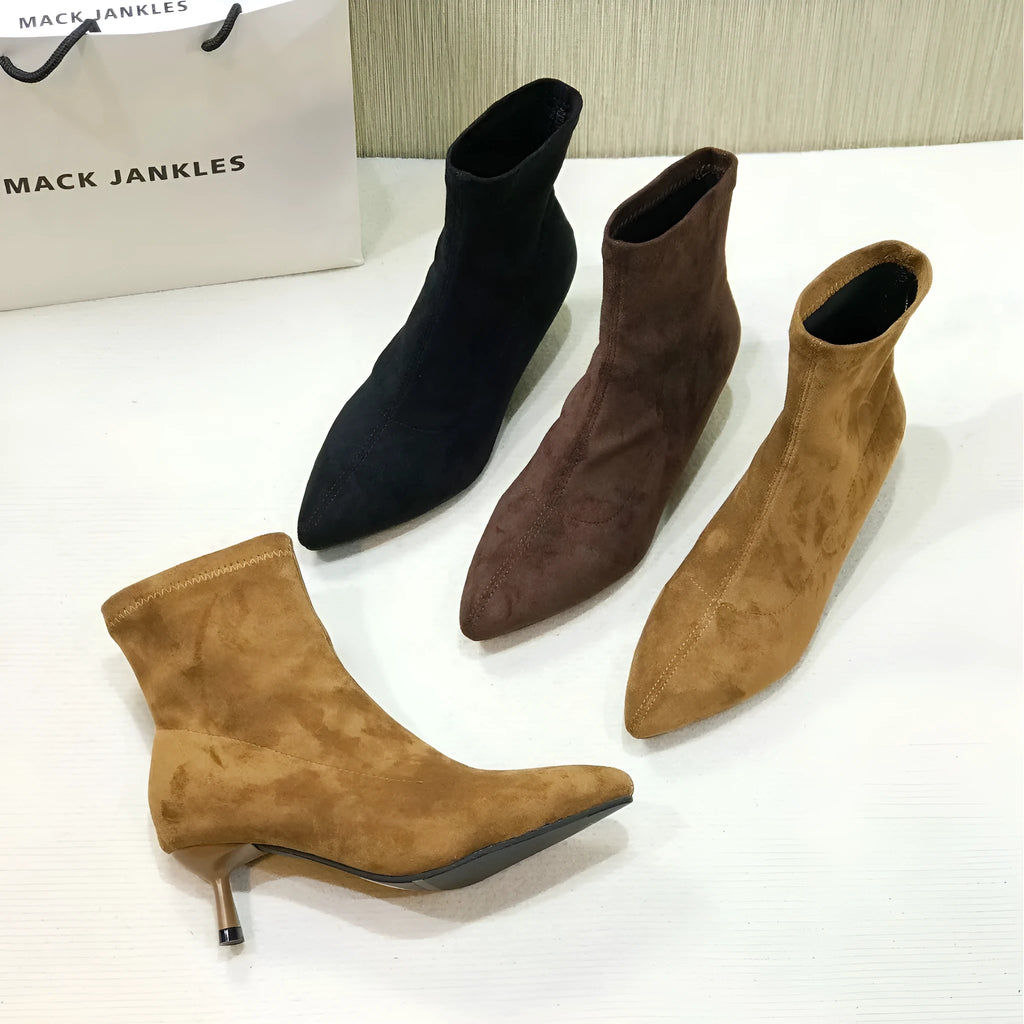 Black pointed toe women's ankle boot with high stiletto heel and mid-calf shaft on a plain background.