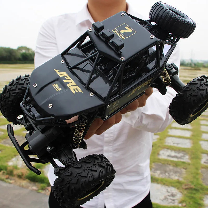 Black and silver 2.4G wireless remote control four-wheel drive car on a rough surface.