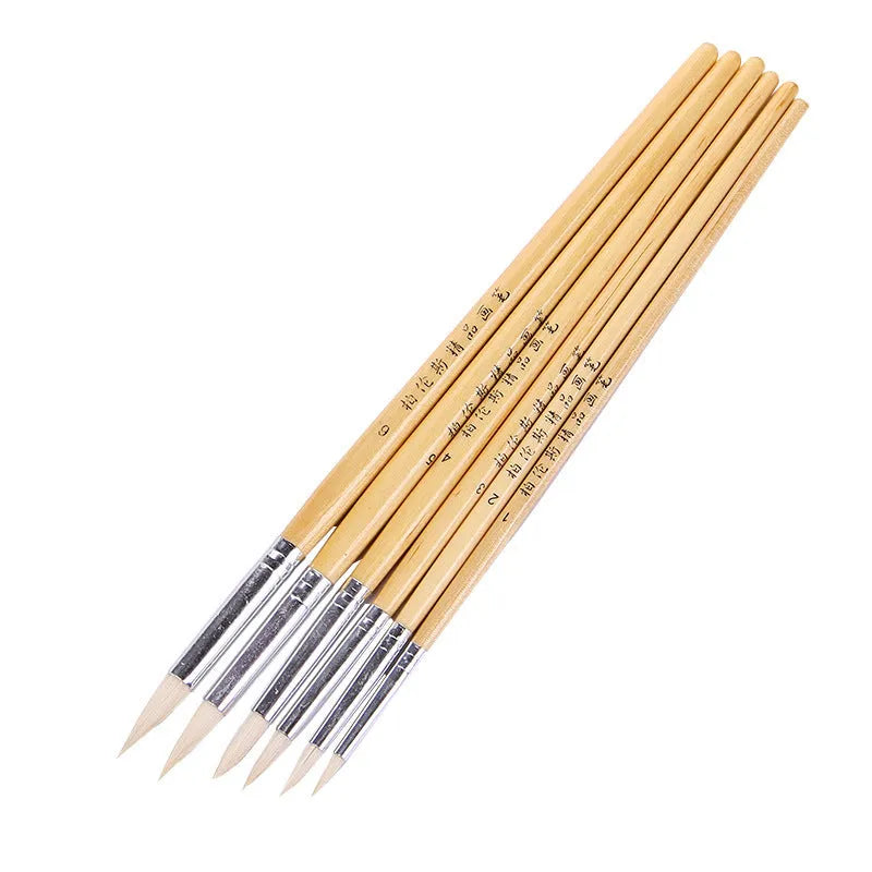 Six wooden-handled pointed pen brushes for wool and fabric crafts laid out together.