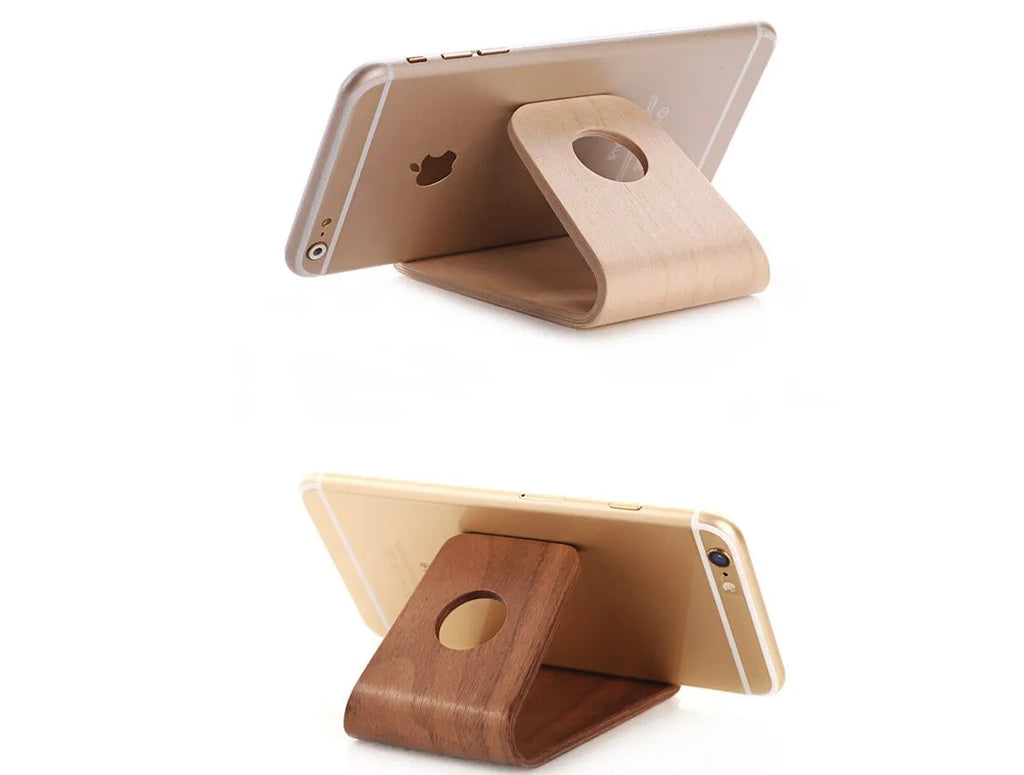 A wooden phone stand holding an iPhone in landscape mode on a desk.