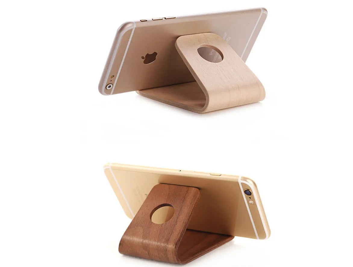 A wooden phone stand holding an iPhone in landscape mode on a desk.