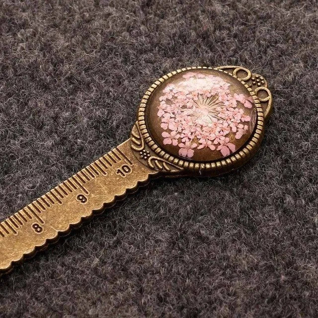 Handmade dried flower bookmark ruler with gypsophila, lace flowers, and clover, 12cm long on a book page.
