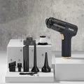 Black cordless handheld car vacuum cleaner with attachments including brush head and inflation nozzles.