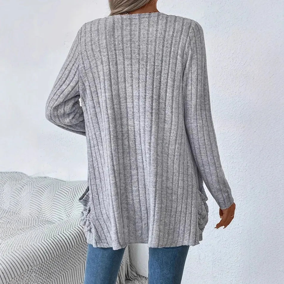 Long sleeve loose fit cardigan in grey with a pocket, shown on a hanger.