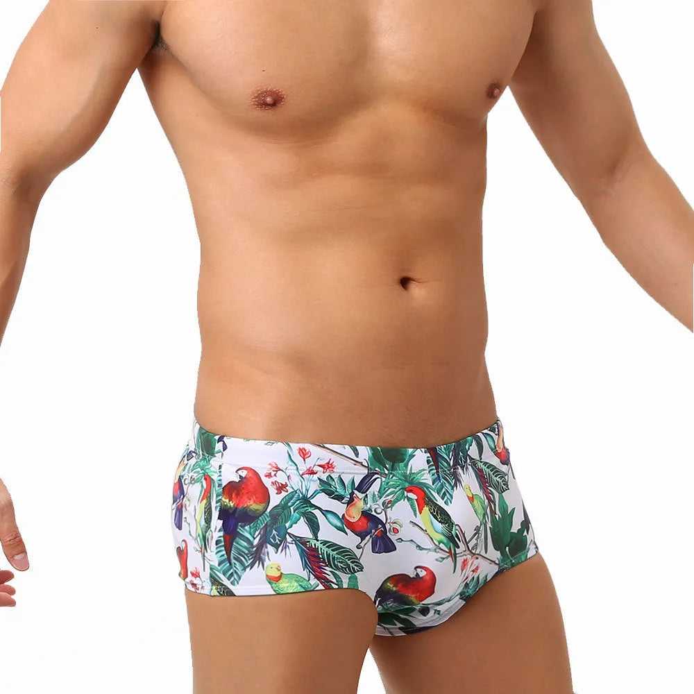 Men's navy blue swimming trunks with colourful flower and bird print pattern.