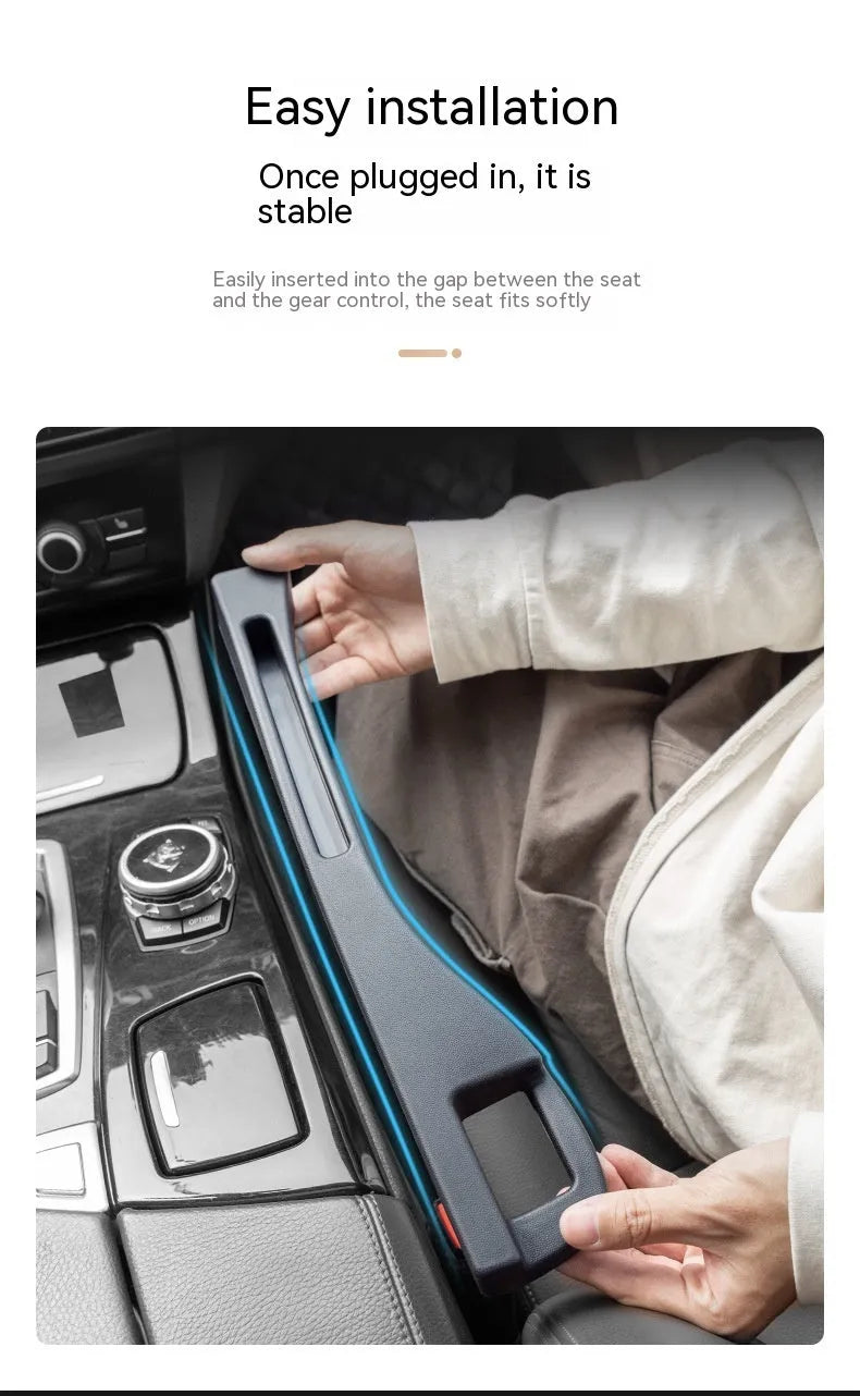 Black plastic car seat gap storage box with handle inserted between car seats.