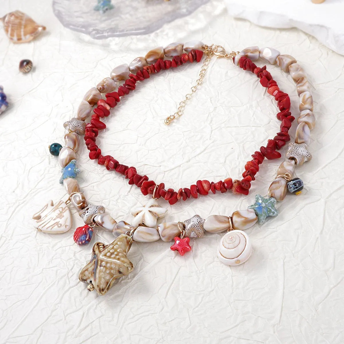 Gold marine life clavicle chain with conch shell and starfish pendant on display