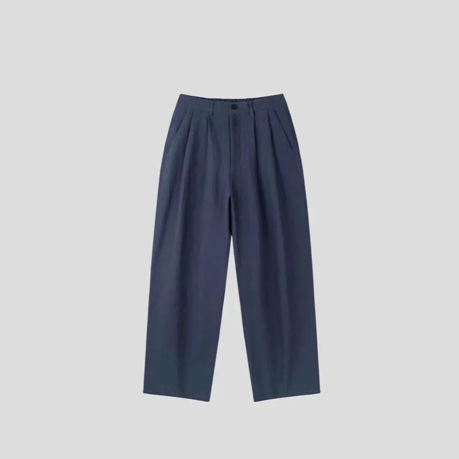 Men's light-weight wide-leg cotton linen trousers in apricot colour, showing loose fit and zip placket.