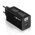 White GaN 65W USB-C fast charger plug with UK, EU, and US attachments on a desk.