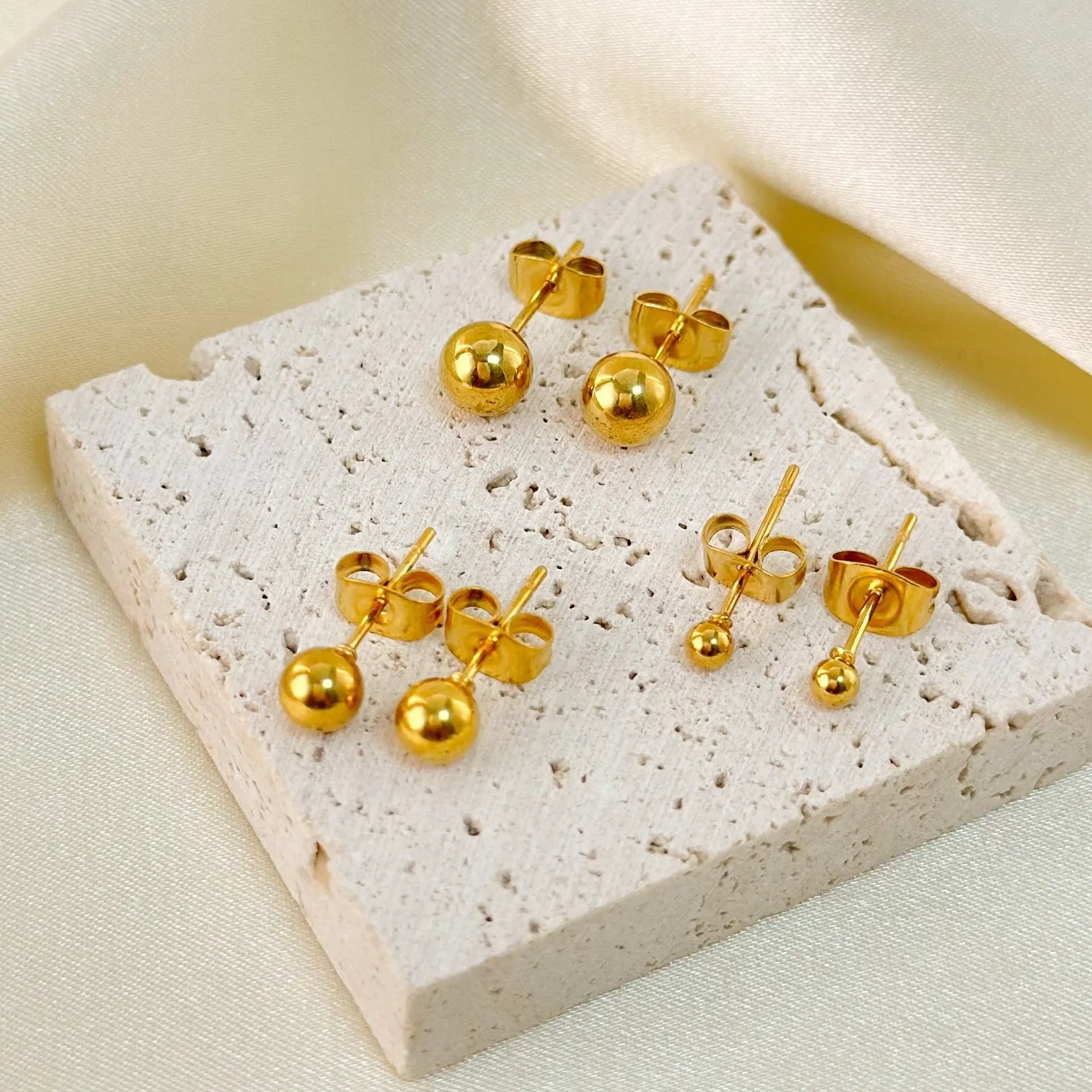 Stainless steel round ball stud earrings in gold or silver, showing 3mm, 4mm, 5mm, and 6mm size options.