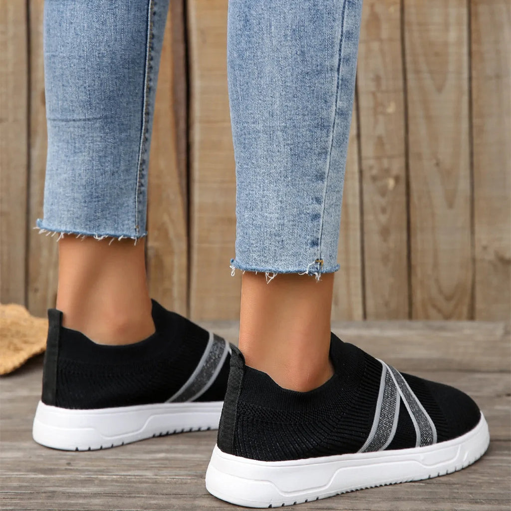 Black women's flat casual shoes with fabric mesh uppers, tassel detail, and a rubber sole.