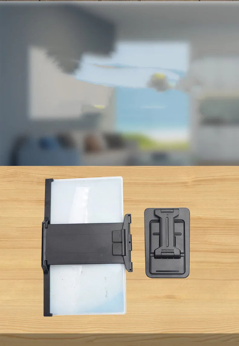 Black folding mobile phone screen amplifier with detachable holder on desktop