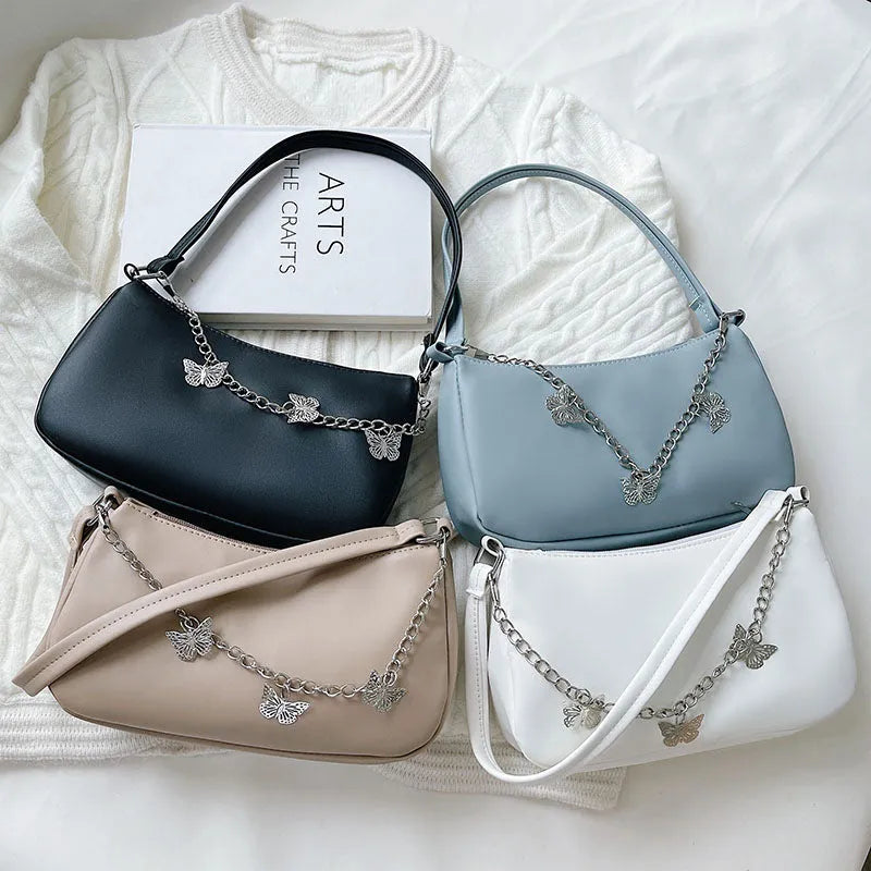 Women's black PU leather butterfly chain crossbody bag with convertible strap showing internal organisation compartments