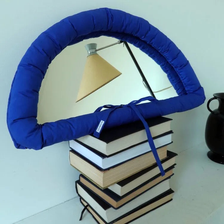 Hanging soft cotton-filled fabric mirror in solid colour on wall