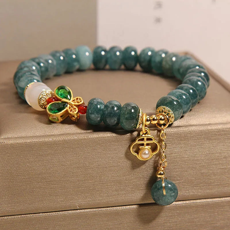 Women's blue water jade abacus bead bracelet with alloy charms, white agate, and rhinestone details