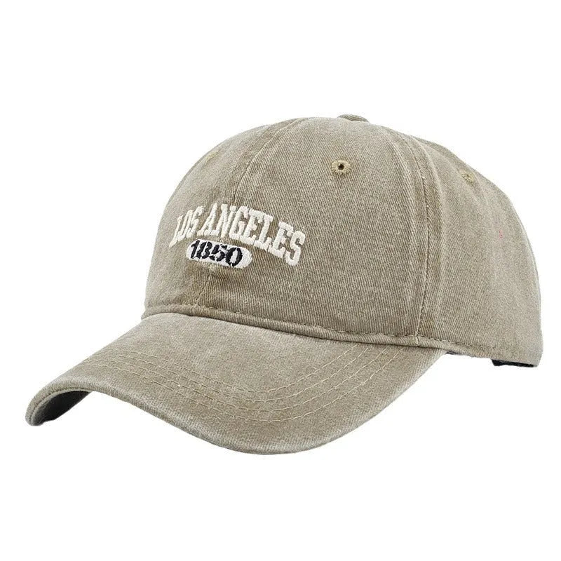 Retro-style adjustable acrylic peaked cap with embroidered letters, shown in a distressed beige colour.