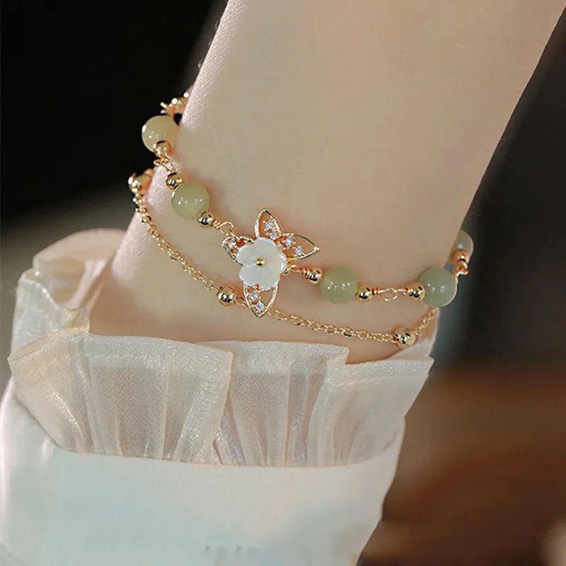 Women's yellow gold electroplated copper butterfly bracelet with geometric shell flower design and Hetian jade stone.
