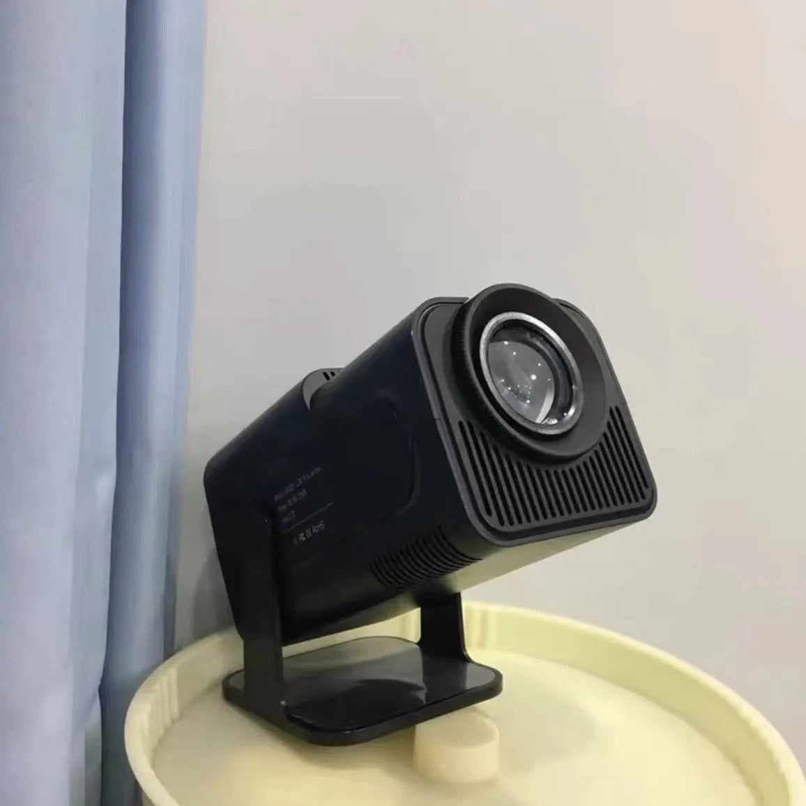 Home projector unit with carrying handle showing 720p HD and wireless projection features