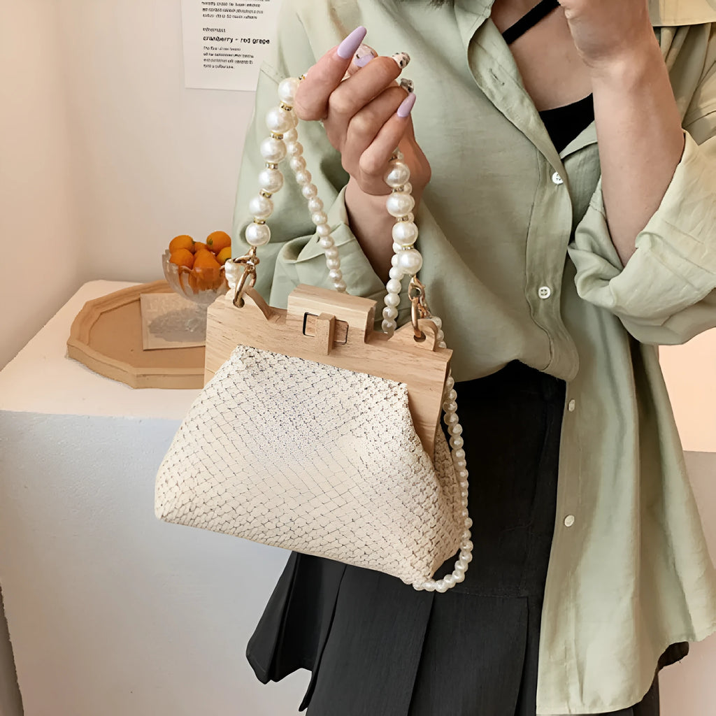 Women's horizontal square straw shoulder bag with pearl chain strap, shown in beige colour with visible sewing line detail.