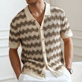 Short-sleeved yellow corrugated knit sweater with flocking detail on a hanger.