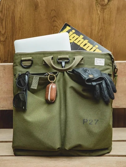 Military green canvas messenger bag with shoulder strap and zip closure showing internal phone pocket