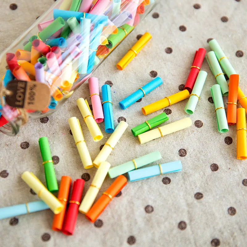 Assorted coloured mini paper scrolls with eyelets in 3x7cm and 7x7cm sizes for drift bottles