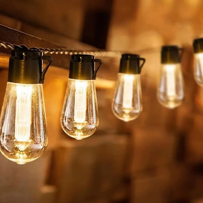 10 metre long retro infusion bottle shaped solar string lights draped outdoors with IP55 waterproof rating.
