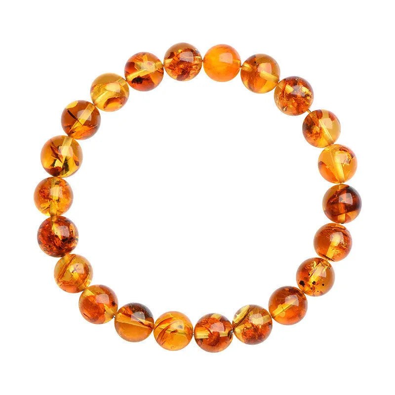 Natural yellow piebald amber bracelet with geometric beads on wrist.