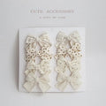 Set of fabric dovetail bow hair clips for children in various colours including beige, pink, and blue flowers.