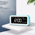 Blue rectangular LED multicoloured atmosphere light alarm clock with digital display on a desk.
