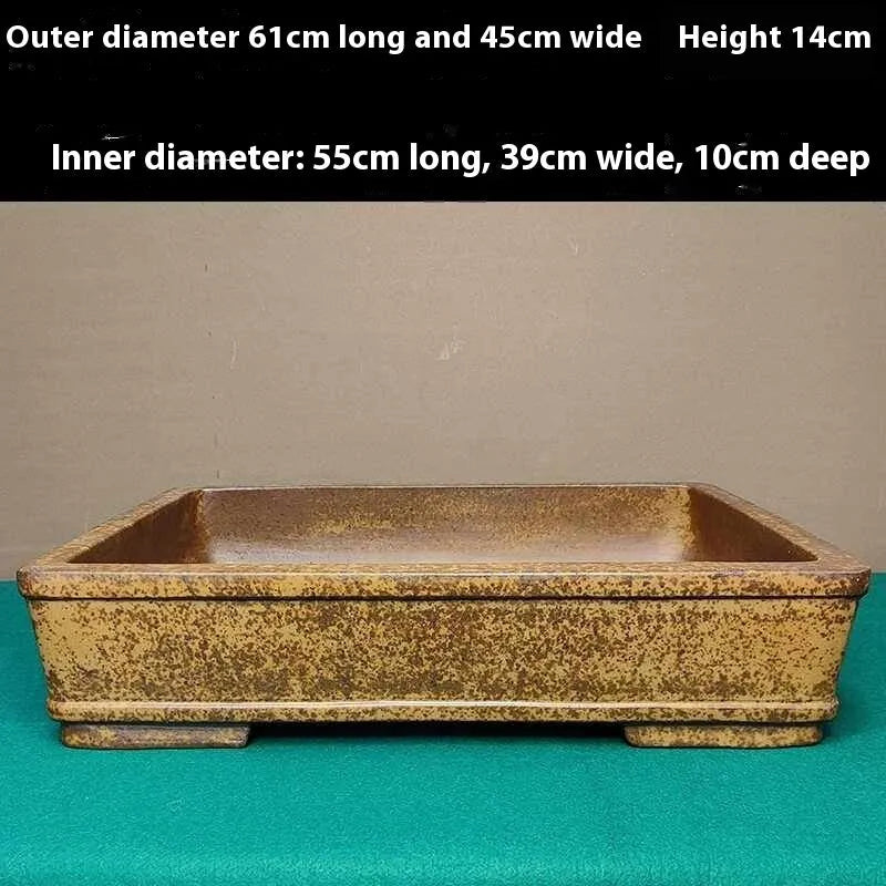 Straight shallow rectangular Yixing zisha purple sand flowerpot on a solid surface.