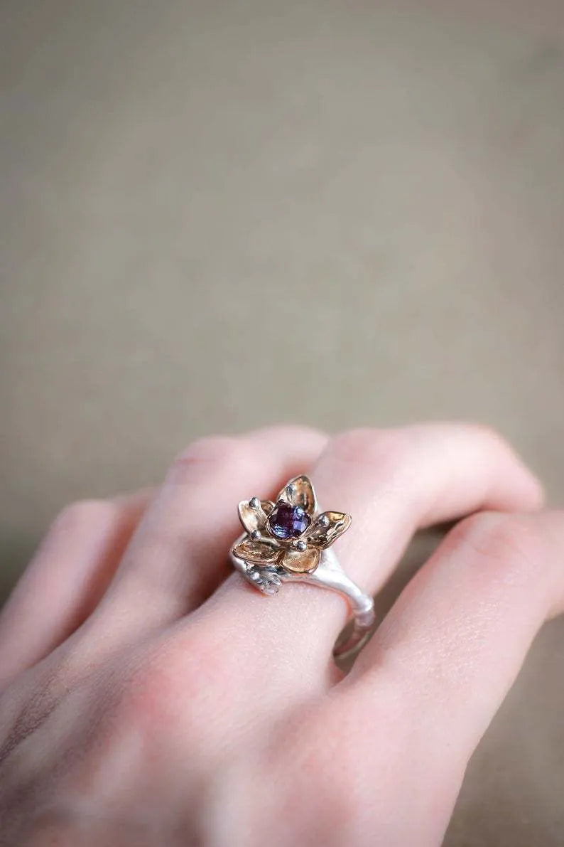 Silver two-tone women's ring with geometric shape and floral detailing on a hand.