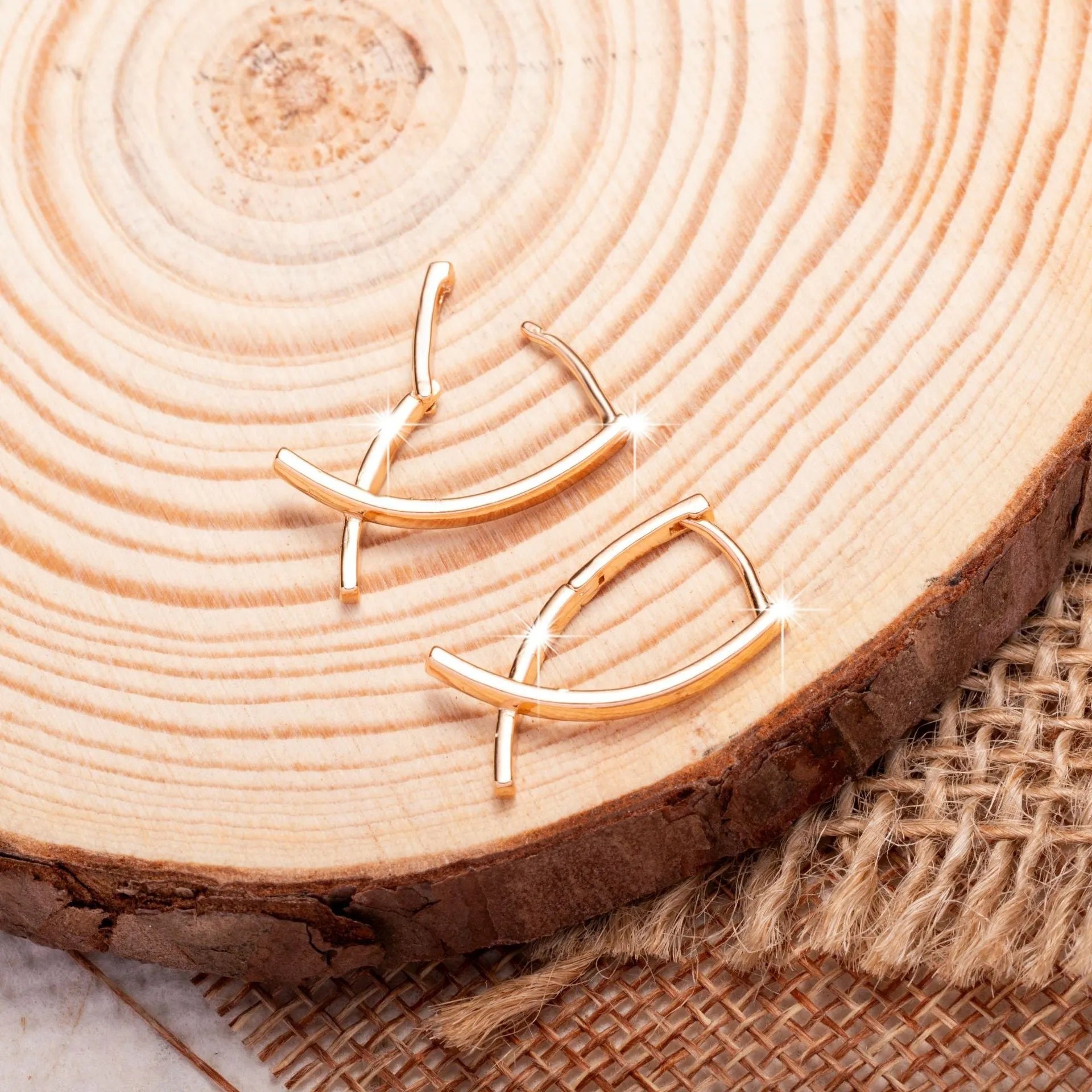 Rose gold cross shaped earrings with copper construction on display card