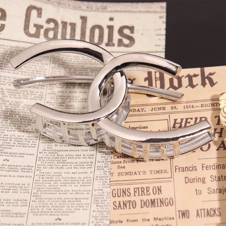 Assortment of silver metal hair barrettes and claw clips in various Korean-style designs on a white background.