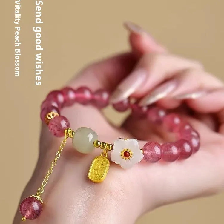 Handmade strawberry quartz crystal bracelet with a choice of moon, XINGX, or pearl charm on a natural crystal band.