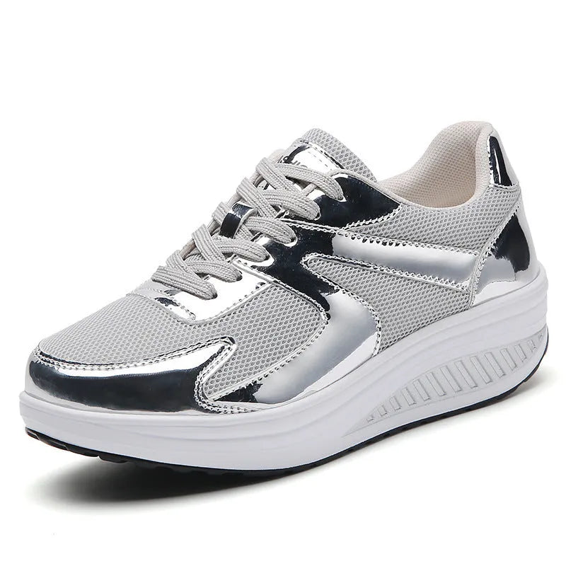 Gold women's mesh platform trainers with cross strap and thick sole on a white background.