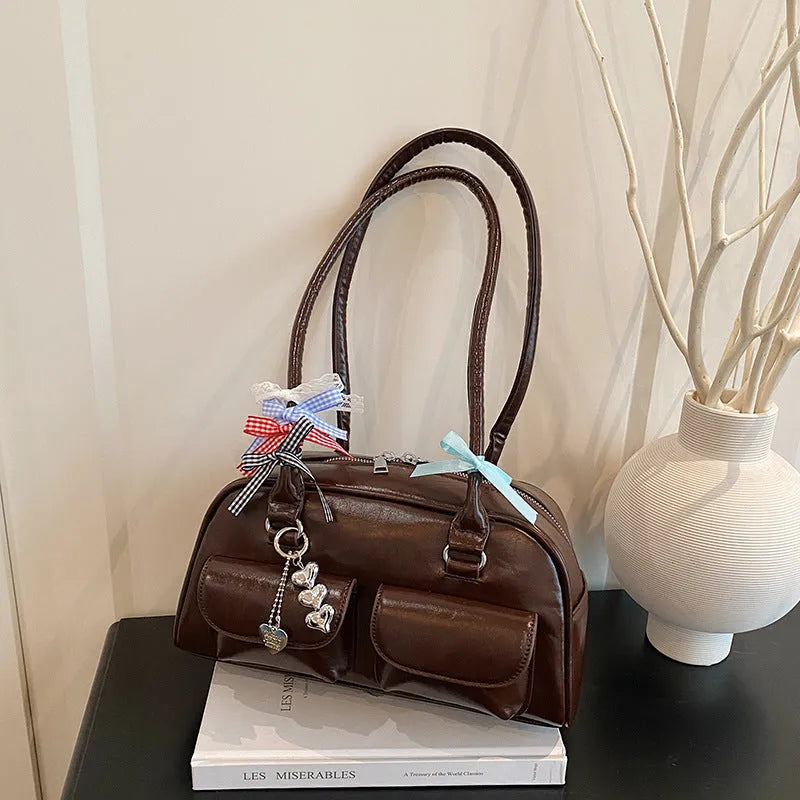 Retro pillow-shaped PU leather women's handbag with double shoulder strap in black colour with ribbon pendant