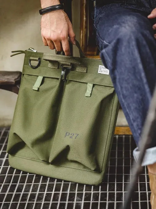 Military green canvas messenger bag with shoulder strap and zip closure showing internal phone pocket