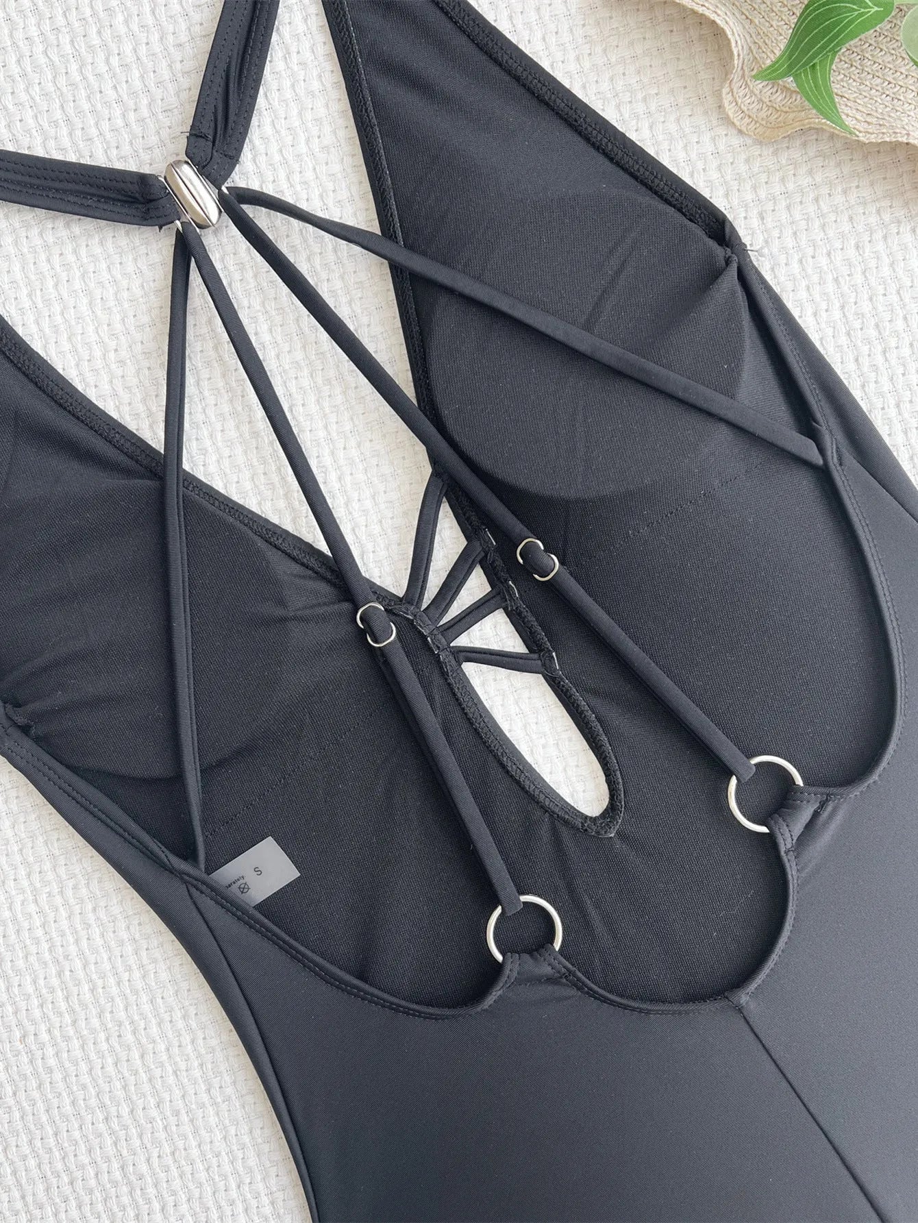 Black solid colour one-piece ladies swimsuit on a mannequin, front view.