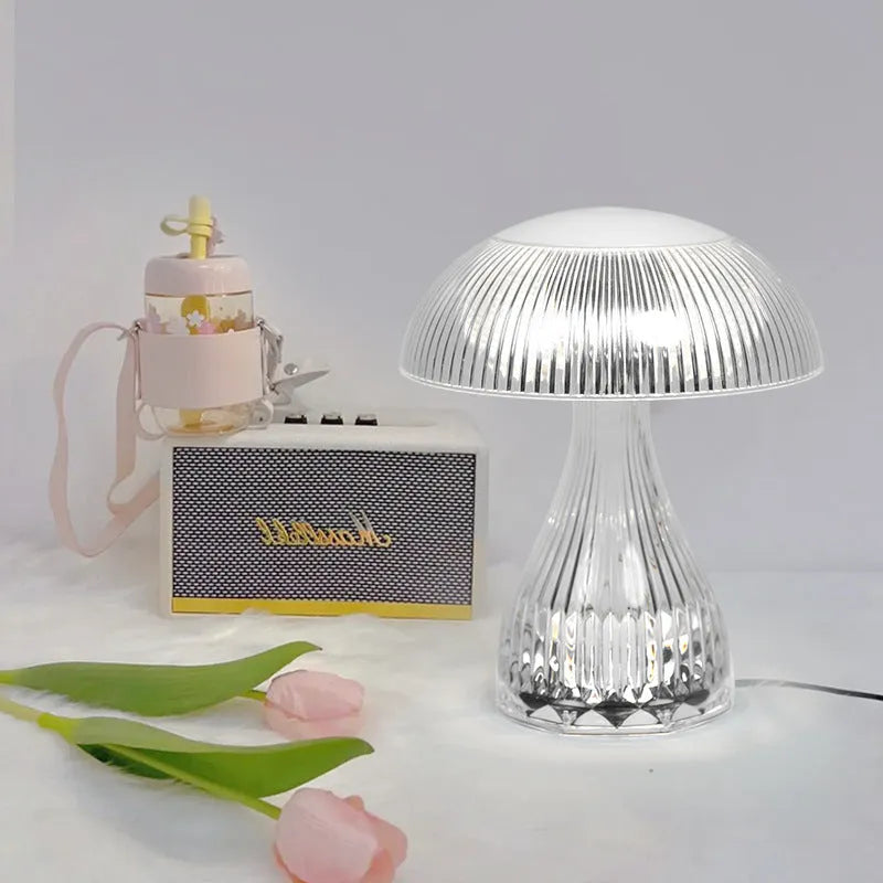 Small white rechargeable table lamp with acrylic body and USB cable, showing three colour light settings.