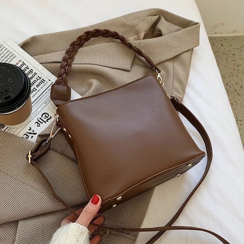Retro style brown PU leather underarm bucket bag with woven design detail.