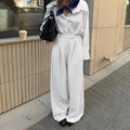 White striped wide-leg women's trousers with a loose fit and zipper fastening on a hanger.