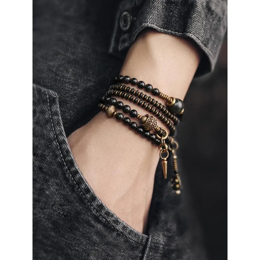 Black multi-layered beaded bracelet with geometric styling on wrist