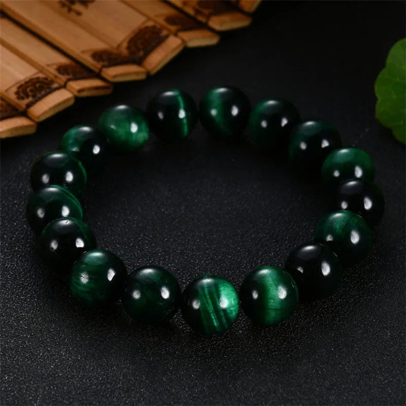 A green tiger eye stone beaded bracelet with geometric polished beads on an adjustable cord.