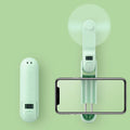 Green folding USB rechargeable mini desk fan with plastic blades on a white background.