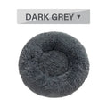 Fluffy grey donut-shaped dog bed with raised plush edge on a wooden floor.