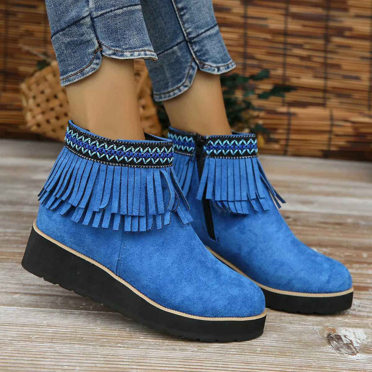 Women's suede ankle booties with a wedge heel, side zipper, tassel detail, and thick rubber sole.
